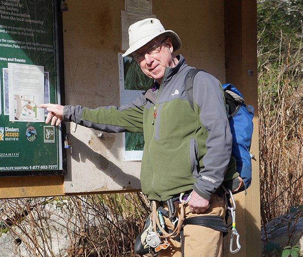 Brian Moorhead of the Smoke Bluffs Advisory Committee points at a sign that shows where the proposed playground will be at the entrance to Smoke Bluffs Park.