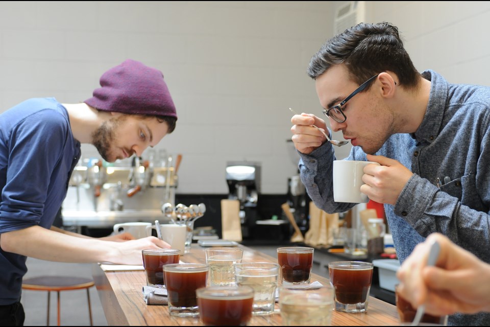 Left to right: Timothy Helmuth and Christopher Rodgers carefully slurp, discuss and take notes during a staff tasting session at Elysian Coffee.