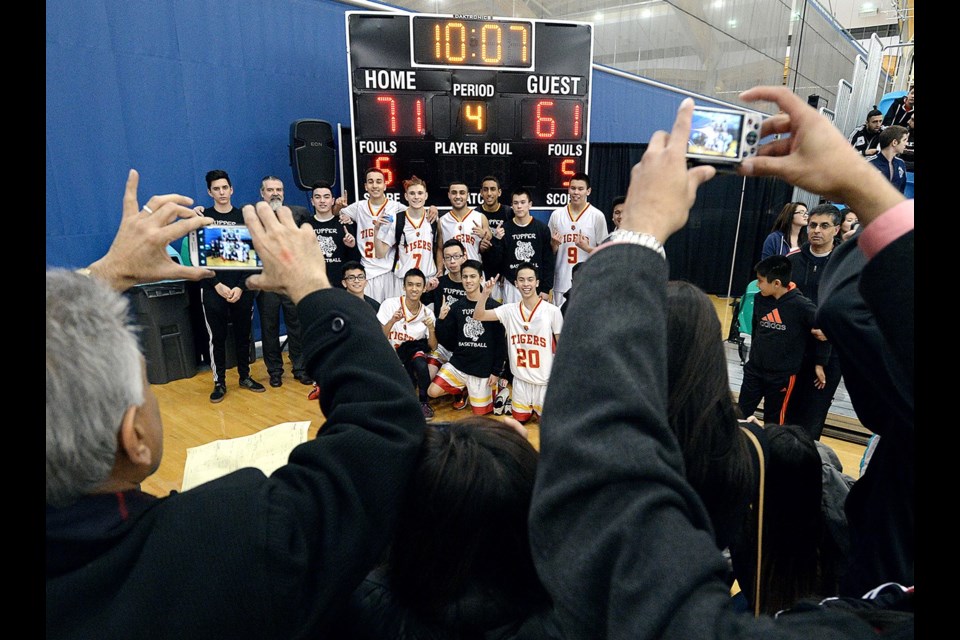 The Tupper Tigers celebrate winning the senior boys AAA Lower Mainland championship after beating the McMath Wildcats 71-61 at the Richmond Oval on Feb. 27, 2015.