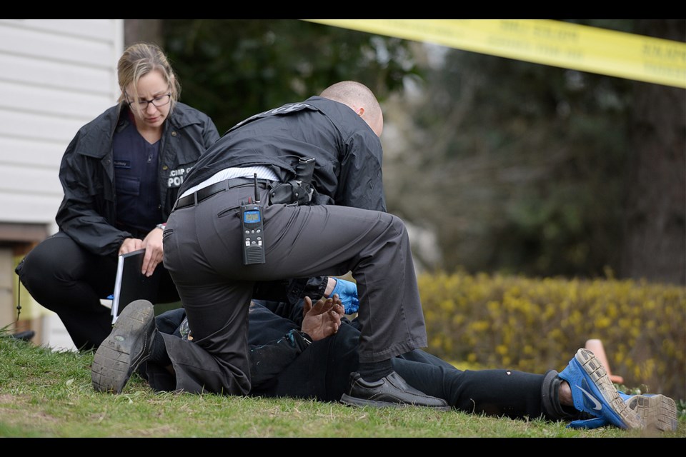 Burnaby RCMP handcuff the suspect of an alleged assault at a home in the 6200 block of Rumble Street Sunday.