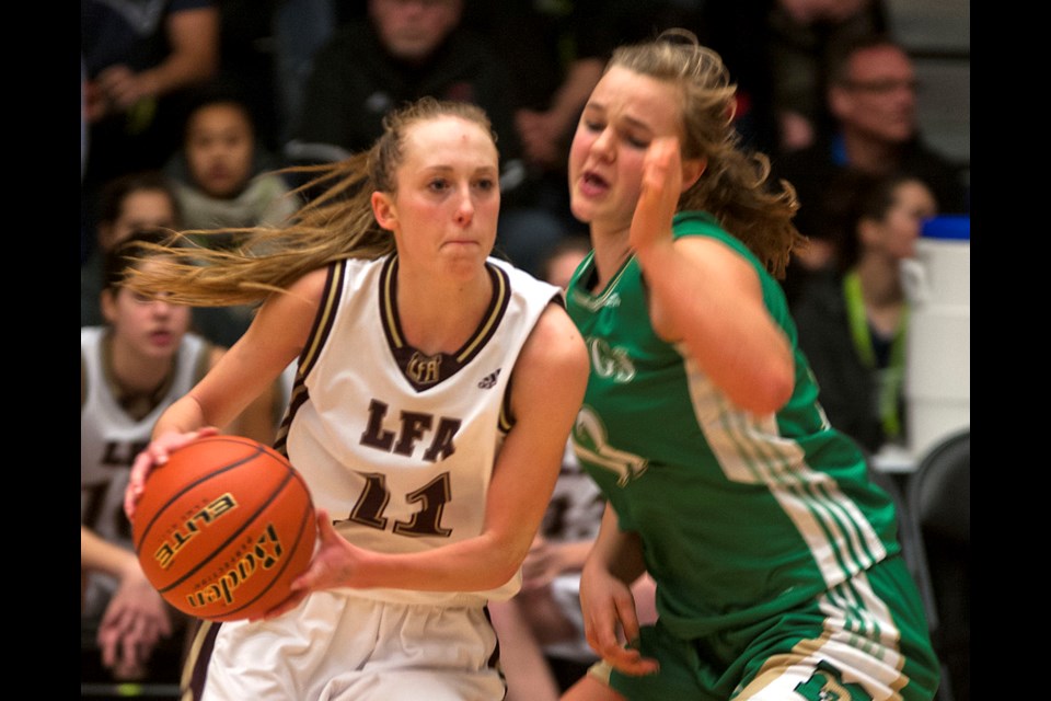 Little Flower Academy's Jessica Hanson (No. 11) is shadowed by Immaculata's Emma Johnson (No. 13) as she looks for two of her game-high 31 points in the senior girls AA B.C. basketball championship final at the Langley Event Centre March 7, 2015. Hanson was named the tournament MVP despite LFA losing to Immaculata 68-55. Photo Chung Chow