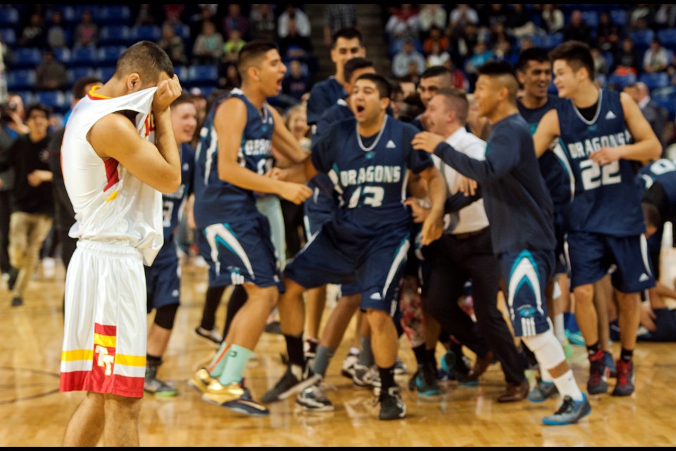 Tupper Tiger Justin Cuenta (No. 5) walks back to his bench as the Fleetwood Park Dragons celebrate a 73-65 win in the senior boys AAA basketball championship at the Langley Events Centre March 14, 2015. Photo Chung Chow