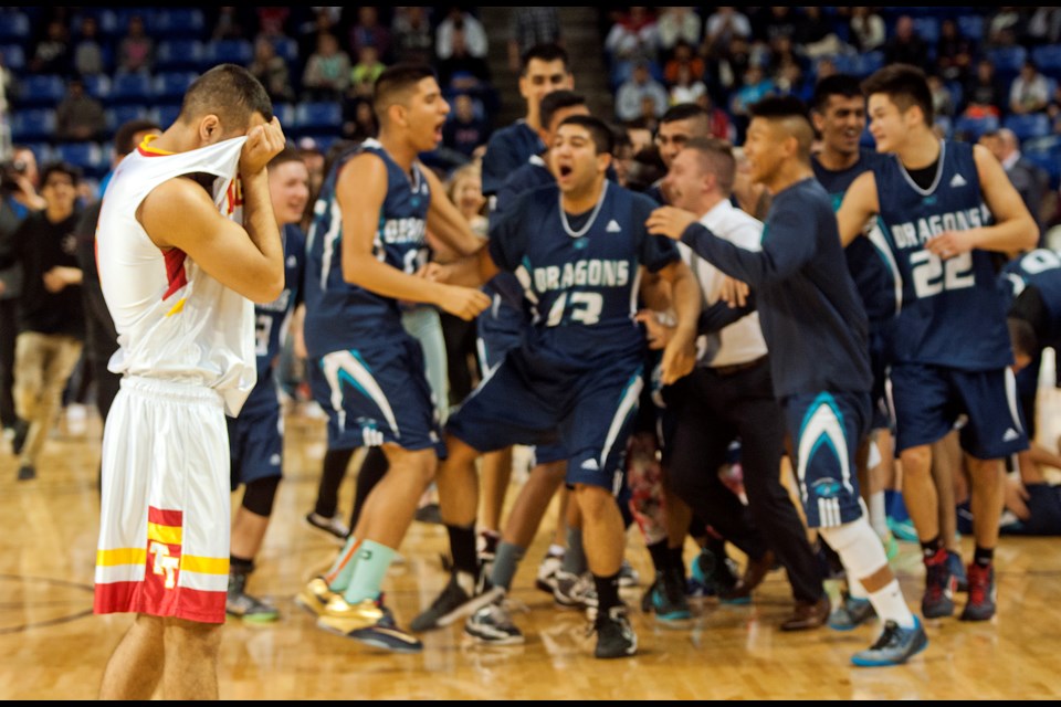 Tupper Tiger Justin Cuenta (No. 5) walks back to his bench as the Fleetwood Park Dragons celebrate a 73-65 win in the senior boys AAA basketball championship at the Langley Events Centre March 14, 2015. Photo Chung Chow