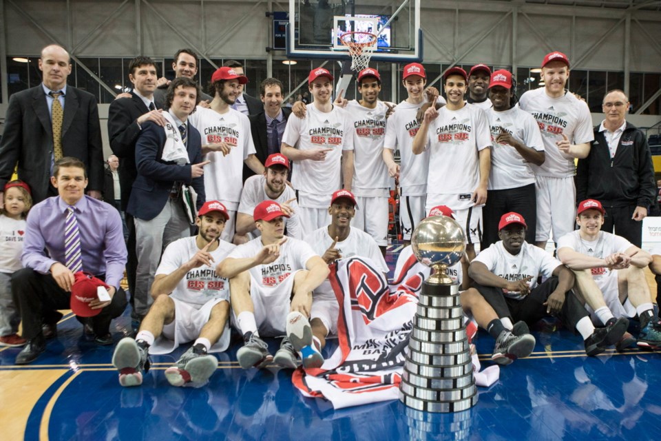 Carleton Ravens pose with the trophy after defeating the Ottawa Gee-Gees to win the CIS basketball final action in Toronto on Sunday.