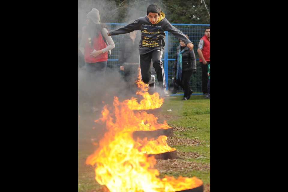 Erfan Rajaeiehtook, 12, jumps over fire as part of Fire Festival. Photo: Dan Toulgoet