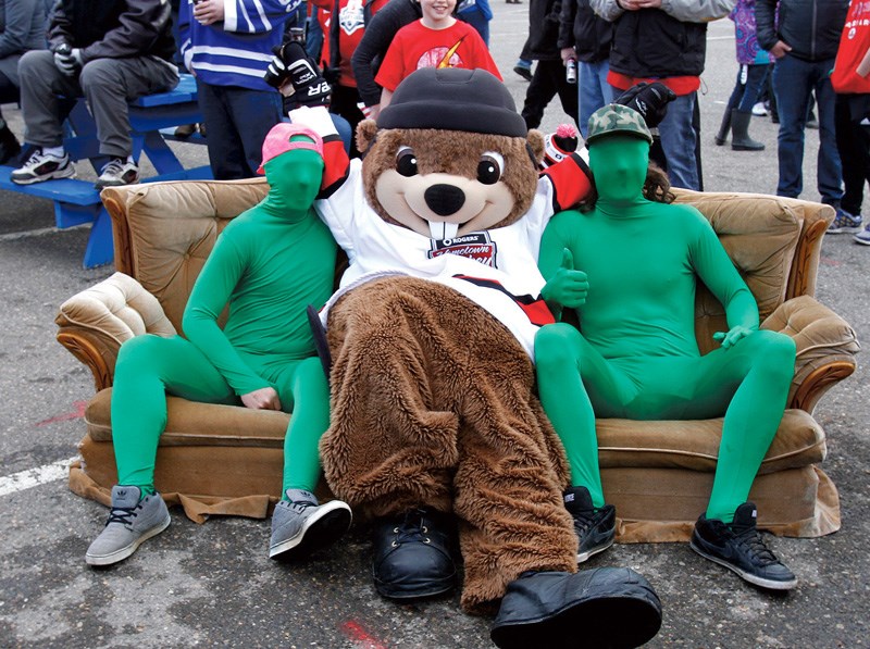 The Green Men relax on a couch with Hometown Hank as they prepare to watch the Vancouver Canucks vs Arizona Coyotes game at CN Centre Sunday.