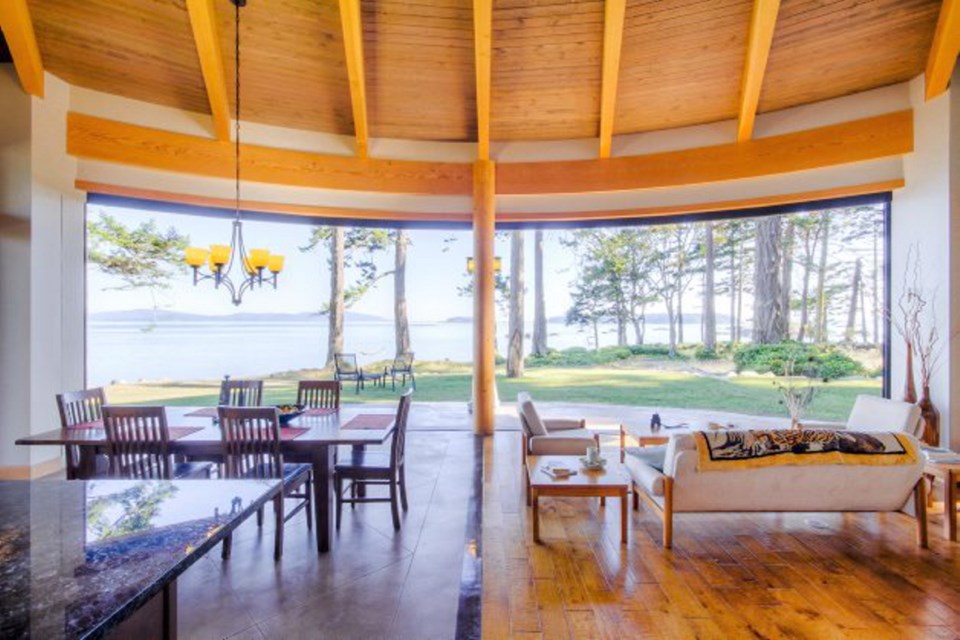 This artistic and unique R. Parson's Construction home features a 10-metre-wide, curving glass wall in the main living area that opens onto the south-facing waterfront of Sidney Island.