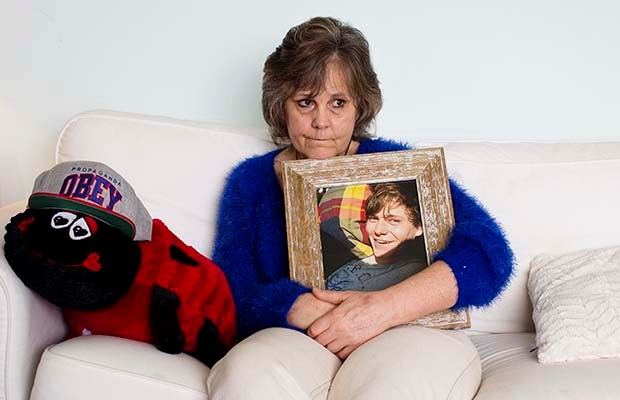 Marney Mutch sits at home in Victoria holding a photo of her son, Rhett, on March 25, 2015. The red ladybug contains the ashes of her son, who was fatally shot by Victoria police in November 2014.
