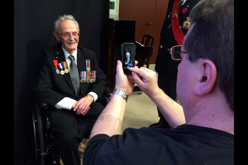 Edmond Champoux smiles as his son snaps his picture after the medal ceremony.