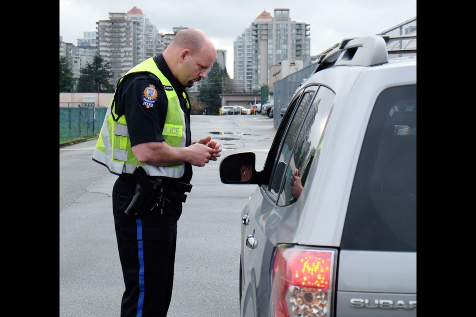 Const. Joe Wright writes a ticket for a driver caught allegedly using their cellphone while behind the wheel. New Westminster police officers were cracking down on drivers using electronic devices behind the wheel. During the two-day education and enforcement blitz, 46 drivers were ticketed.