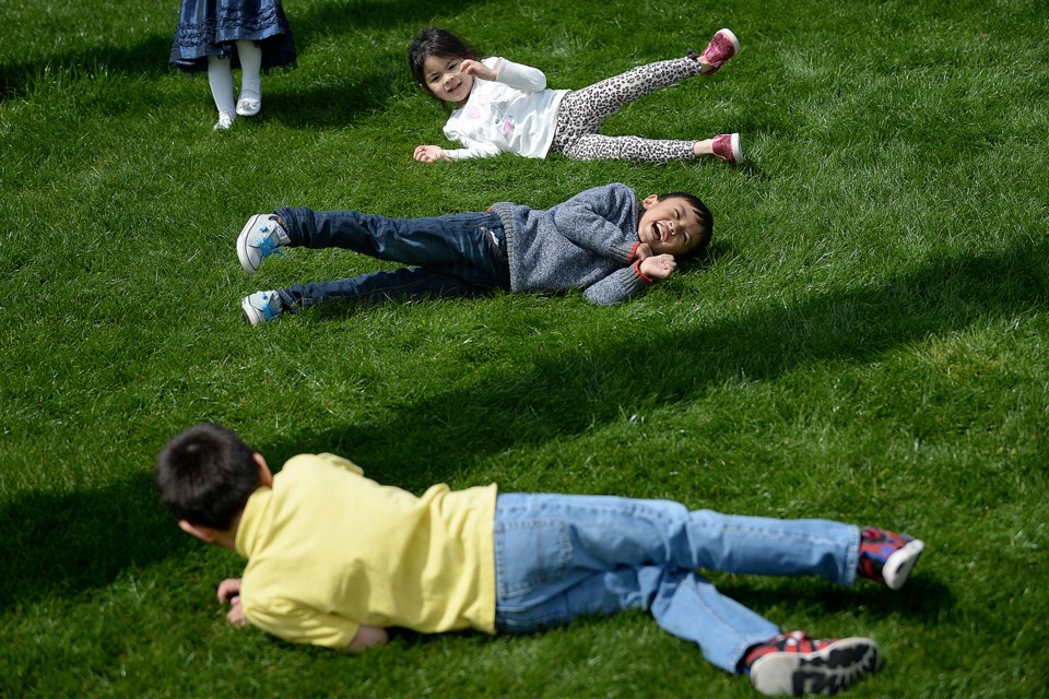 Kali Truong, Karsen Amin, and Logan Mata roll down a hill at Westminster Pier Park. They were out enjoying the Easter Sunday sunshine.