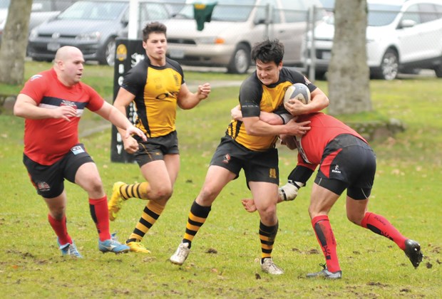 Nathan Yanagiya of the Capilano Rugby Club fights off a tackler while teammate Cody Mastin-Pitman provides support during a CDI Premier League game against the UBC Old Boys earlier this season.