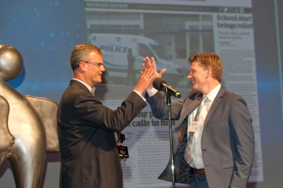 Mike Howell won first place in the coveted John Collision Memorial Award for investigative journalism for his feature story on the problems surrounding the Marguerite Ford social housing complex in the Olympic Village. He's pictured here with Peter Kvarnstrom, president of community media for Glacier Media.