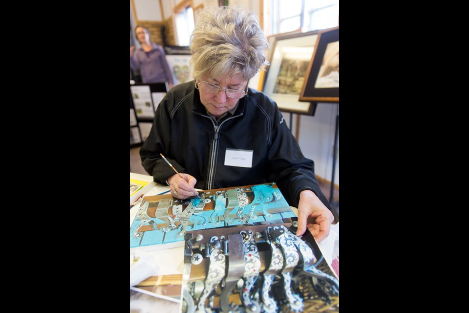 Artist Joyce Trygg works on a piece at the Orphaned Wildlife Society annual open house in Ladner April 25 and 26.