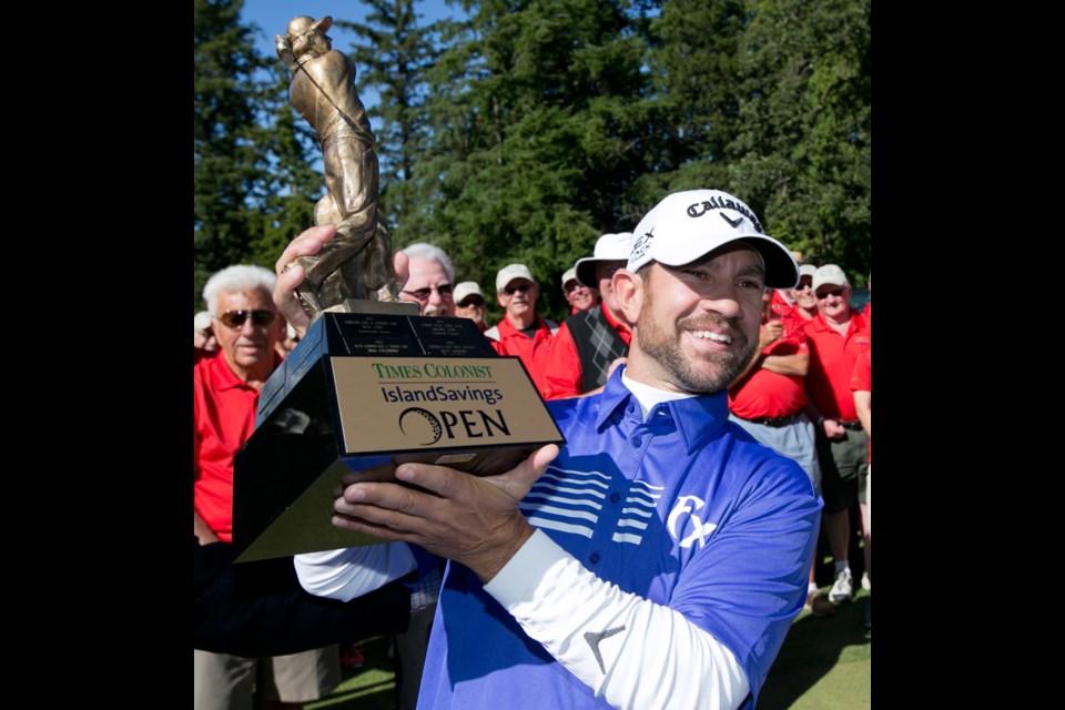 Times Colonist Island Savings Open winner Stephen Gangluff shows off his trophy Sunday at Uplands Golf Club.