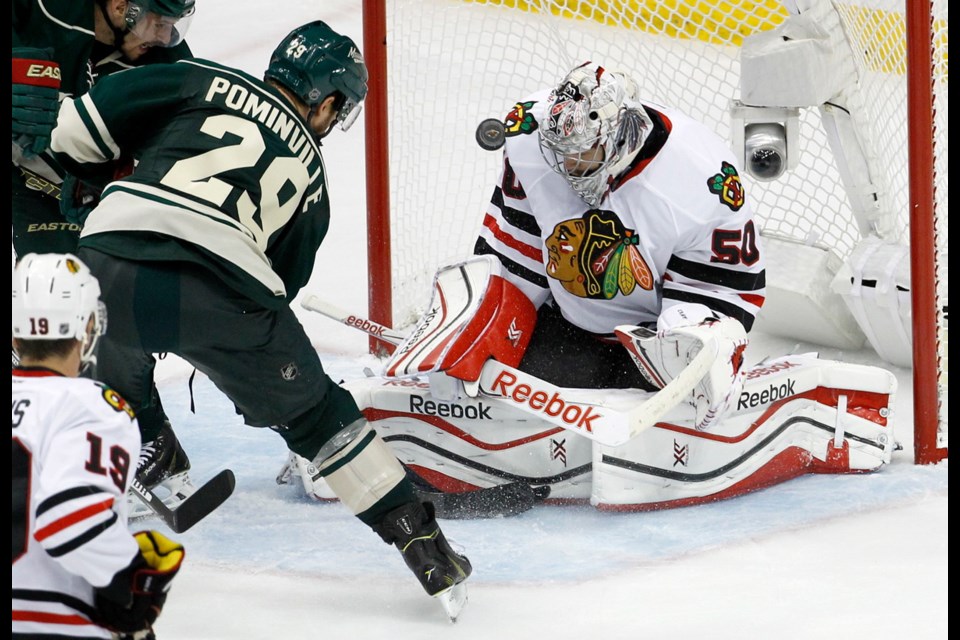 Chicago Blackhawks goalie Corey Crawford (50) deflects a shot by Minnesota Wild right wing Jason Pominville (29) during the third period of Game 3 in the second round of the NHL Stanley Cup hockey playoffs in St. Paul, Minn., Tuesday.