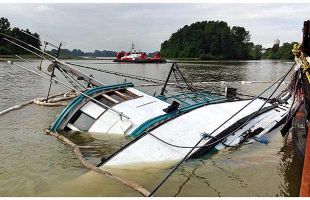 A 26-metre fishing boat that capsized in the Fraser River at a marina in Richmond is spilling fuel in the water. Photograph by: Nick Procaylo, PNG