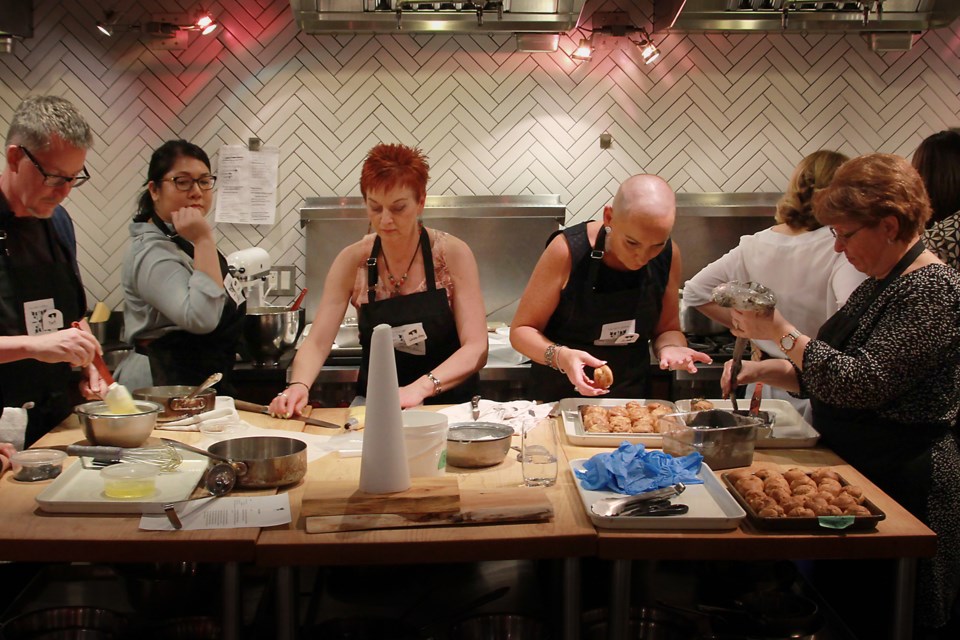 Students work together to create croquembouche.