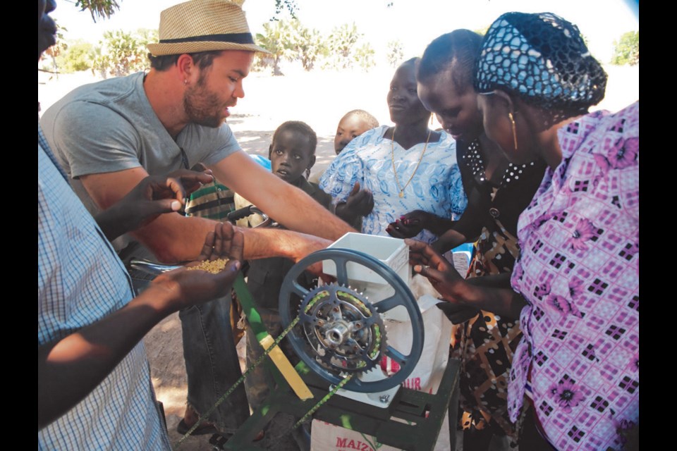 Chris Hergesheimer shows South Sudanese women how the bike mill works.