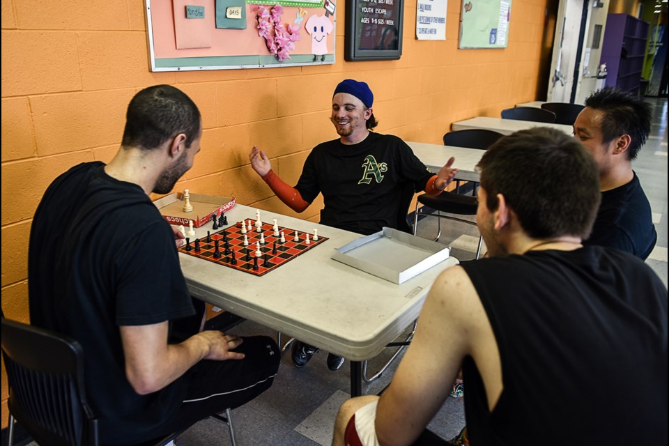 Dodgeball teammates Daniel Lewis, left, and Shayn Solberg keep their minds on alert with a between-game chess match. The players were part of the Go Wild Dodgeball Tournament at the Fraserview Club Saturday. Photograph by: Rebecca Blissett