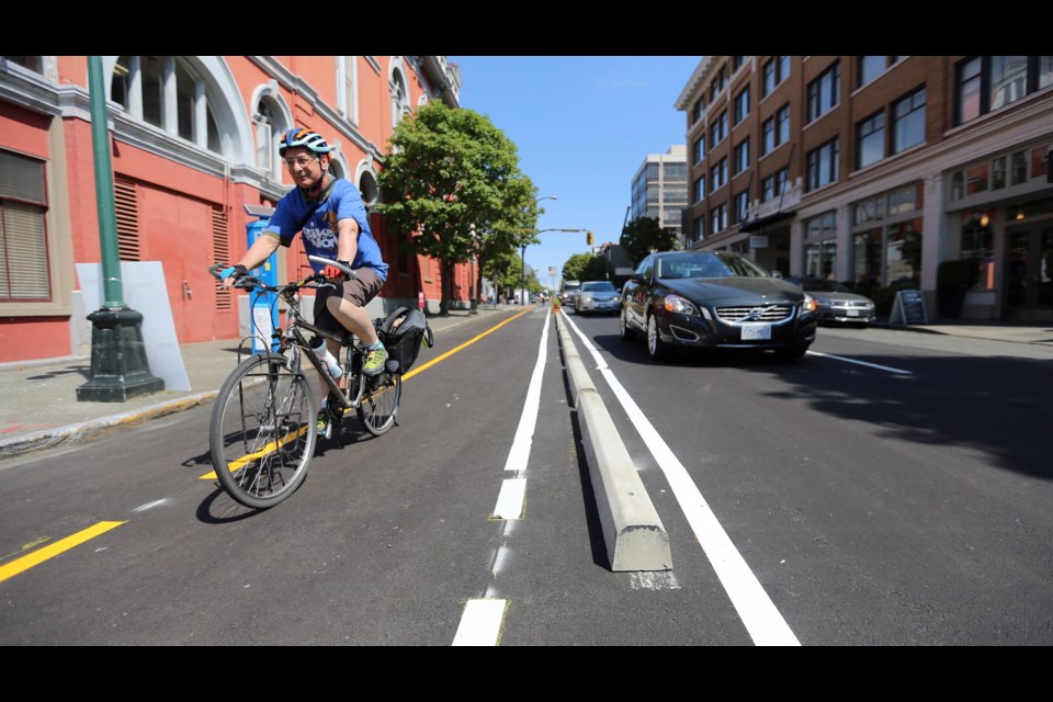 John Luton rides on a temporary or ‘pop-up' protected bike lane on Pandora Avenue adjacent to Victoria City Hall in May. A protected two-way bike lane is planned for Pandora as part of the city's growing cycling network.