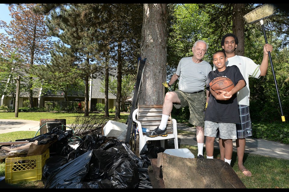 Nick Kvenich, president of the Eagle Creek Streamkeepers Society, with Deandre Beer and Yacob Gugsa of the Greystone Village Tenants Association with some of the trash collected at the fourth annual cleanup.