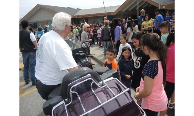 Anderson elementary students meet one of the dozen or so bikers on Friday