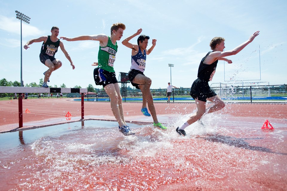 Competitors hit the water in the senior boys steeplechase at the B.C. high school championships at McLeod Athletic Park on June 5, 2015. Photo Jennifer Gauthier