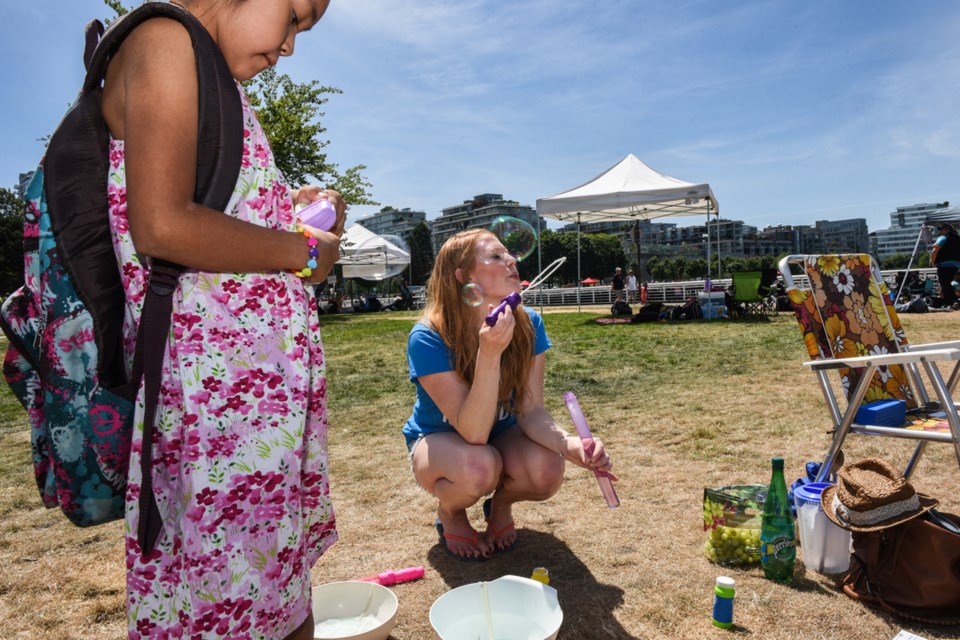 Julia Fryer set up a bubble-blowing station outside Science World for Vancouver’s 100in1 day Saturday. “I want to bring joy through bubbles,” said Fryer. The goal of the international festival is to focus on the role of people and public spaces, and to prove that anybody has the power to improve a community. Photograph by: Rebecca Blissett