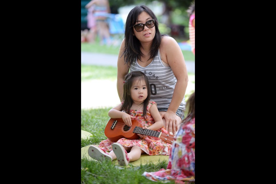 A musical day: Two-year old Ava Man tries out the ukulele at the Ecole Qayqayt Elementary School’s June 6 carnival in Tipperary Park.