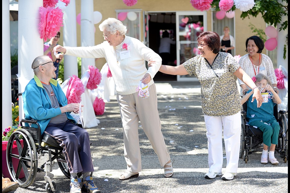 Patti, a resident at Royal City Manor, sprinkles flower petals up the aisle at the June 20 wedding vow renewal ceremony.