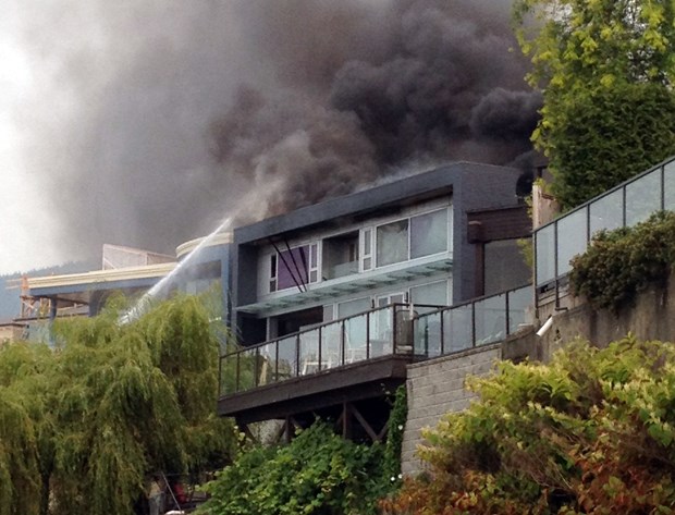 Crews work to put out a fire on the West Vancouver waterfront.