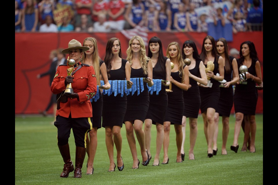Women in little black dresses carry the FIFA awards and medals following the World Cup Final at B.C. Place on July 5, 2015. Photo Jennifer Gauthier