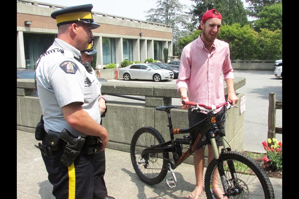 Australian tourist Andrew Cameron, in red, came to B.C. to do some mountain biking but his riding adventure was put on hiatus when his $1,650 bike was stolen from a bike rack outside of Metropolis at Metrotown on May 12. On July 8, Burnaby RCMP returned the bike to Cameron after an undercover investigation recovered the stolen ride.