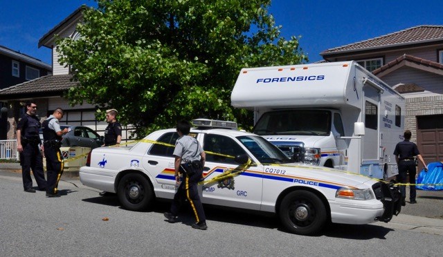 More police arrive on the scene of a Coquitlam home, where two bodies were discovered by RCMP 24 hours prior.