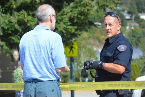 Police talk to workers impacted by the road closure.