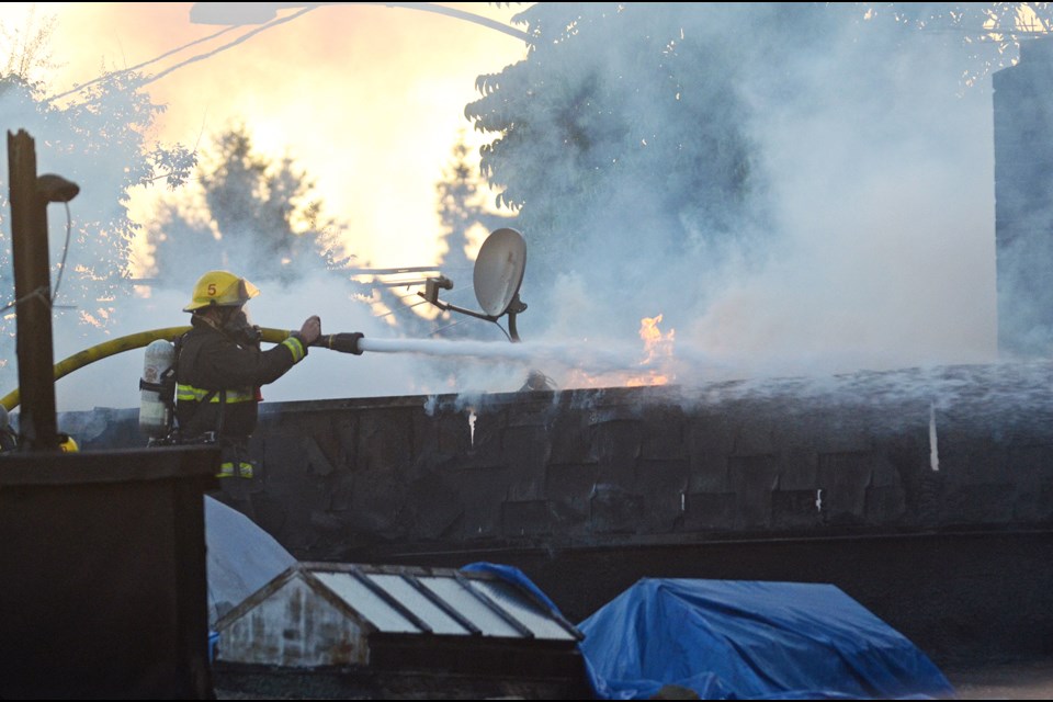 A fire fighter battles a blaze that broke out at the New Venture Coin Laundry laundromat in the 400 block of 8th Street around 6 p.m. Sunday.