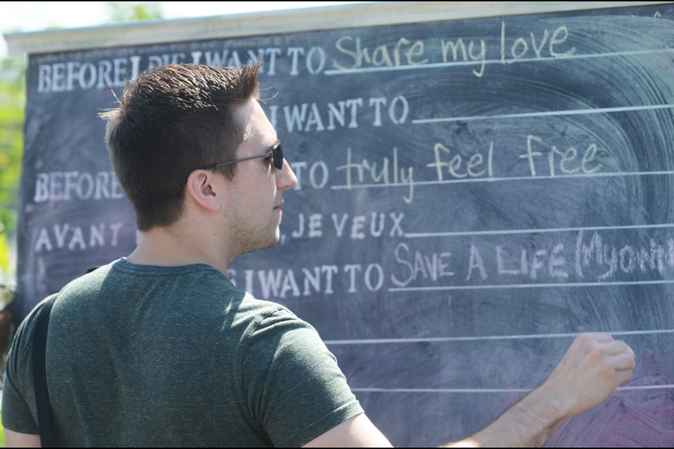 New Westminster resident Jake Flesher fills in the blanks at a Westminster Pier Park public art installation.