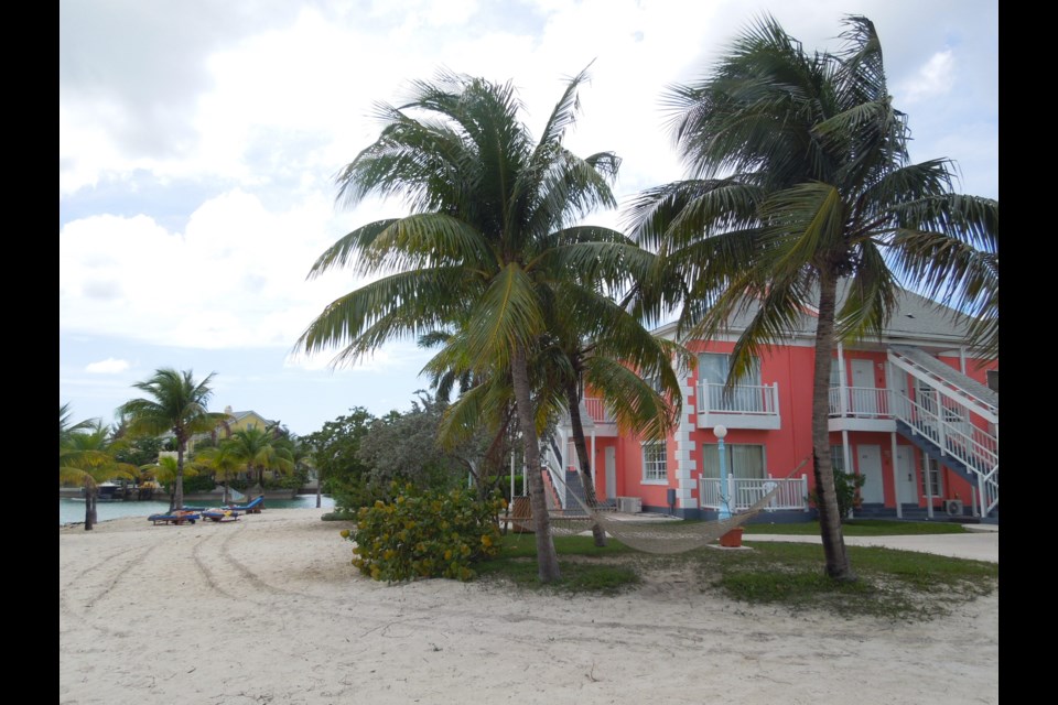 Coconut trees line the beach in front of the colourful villas that make up Sandyport Beaches Resort and Hotel in Nassau, Bahamas.