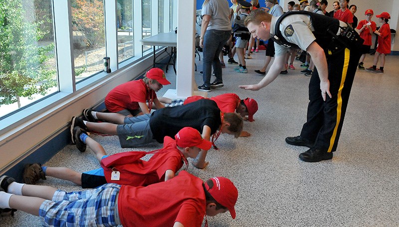 An RCMP officer orders push ups at the Poirier Sport and Leisure Complex.