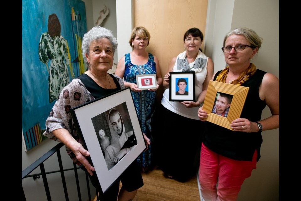 Members of the mumsDU advocacy group hold pictures of their children who died after using fentanyl. From left: Leslie McBain, with a photo of her son, Jordan Miller, who died at 25; Donna May, with Jac, who was 35; Jennifer Woodside, with Dylan Bassler, 21; and Petra Schulz, with Danny Schulz, 25.