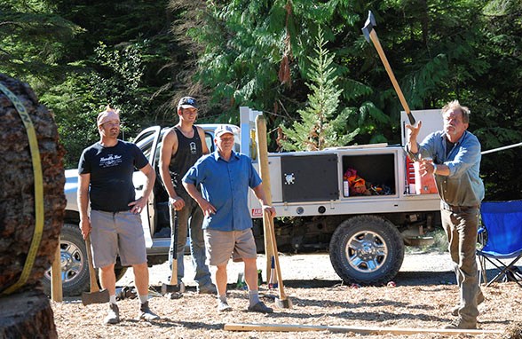 Cody Bentall, Kaid Sander, and Frank Seaberly watch as Gary Anderson practises his double-handed axe-thorwing technique in Anderson’s backyard. Anderson is organizing Bowfest’s Logger Show. Martha Perkin