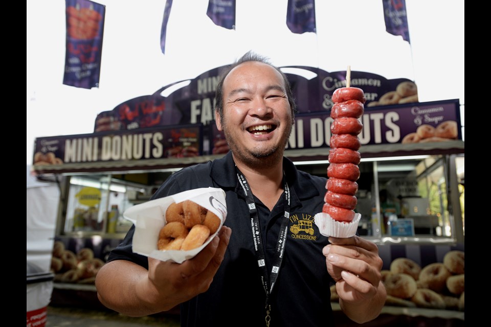 Jason Au of the Mini Donut Factory shows off red velvet mini donuts with cream cheese glaze. The tasty, artery clogging treats are available at this year's PNE. Photo Jennifer Gauthier.