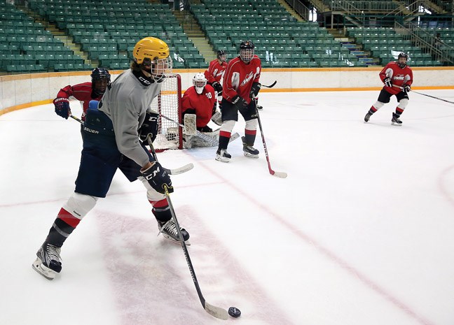A player from Team Chara looks to clear the puck from his zone on Saturday during the Prince George Cougars training camp which saw Team Byfuglien (red) take on Team Chara (grey) at the CN Centre.