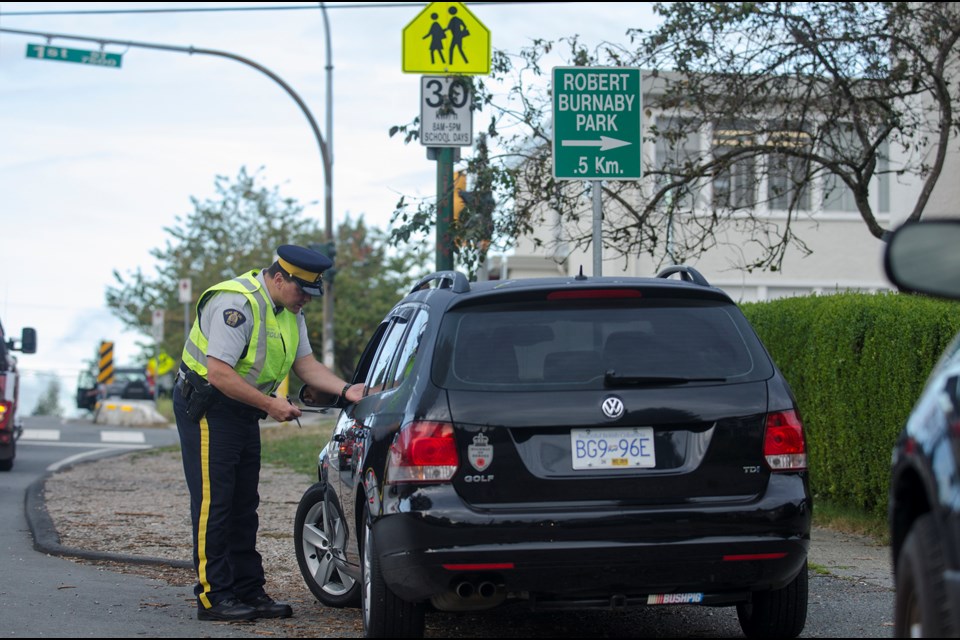 Burnaby RCMP Const. Derek Morosoff writes a ticket for a driver caught speeding in the school zone surrounding Second Street Elementary school on Wednesday. Mounties organized an enforcement blitz at four schools in the city this week to remind drivers to slow down in school zones.