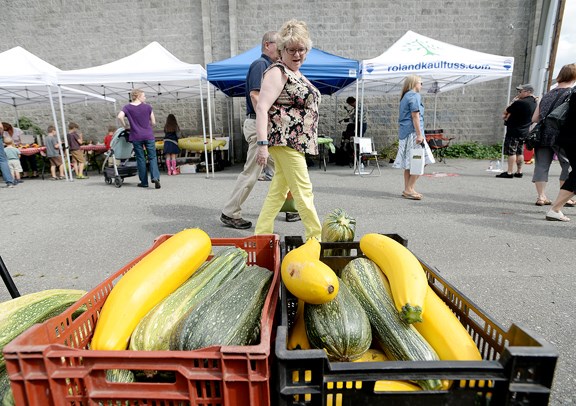 Marianne Janzen eyes the zuchhini and squash at the Royal City Farmer's Market held at Pacific Breeze Winery.