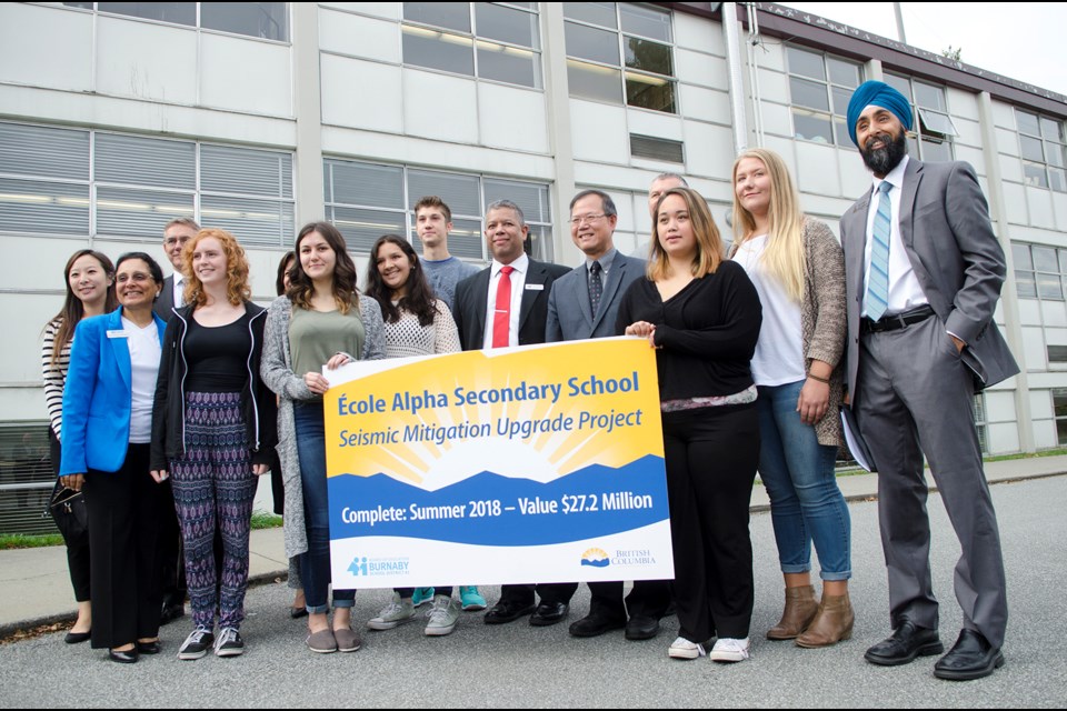 Students, school officials and Burnaby North MLA Richard Lee pose for a photo at Alpha Secondary Wednesday after the announcement of a $27.2-million partial replacement of the high school.