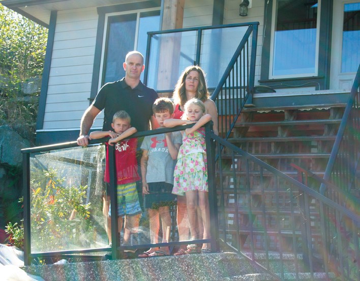 Ross and Erin Storey stand with their children Callum, Joffre and Brynn on the pitched steps of their North Gale Avenue home where a sinkhole caused massive damage to their house this past February. The family is now suing the District of Sechelt, Concordia Seawatch Ltd., several geotechnical and engineering firms, an insurance company and the realtors who sold them the home.