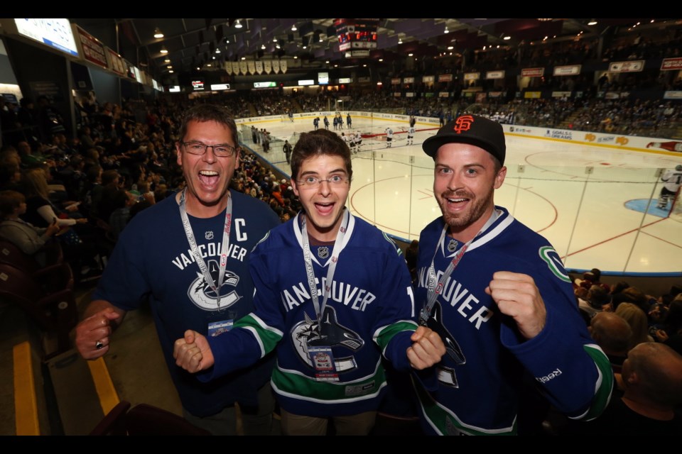 Darryl Johnson, left, son Taylor and Neil Higgins were among diehard Vancouver Canucks fans attending the Hockeyville game at The Q Centre Monday.