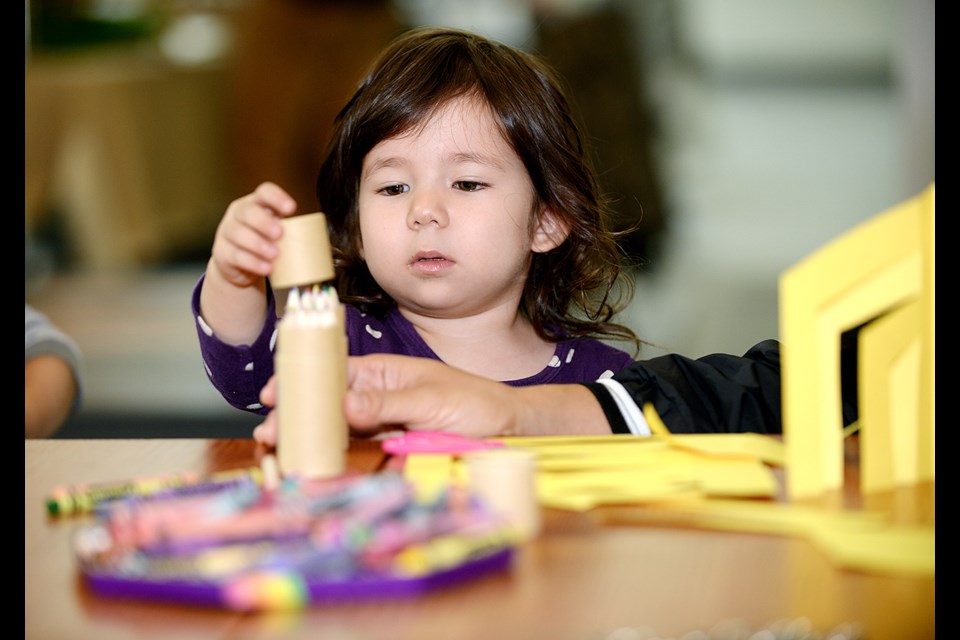 Two-year-old Madison Vaughan gets her hands on some art at the New West Craft fair.